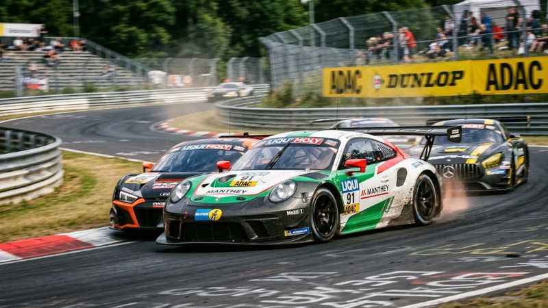 GT3-based race cars competing on a racetrack during a DTM motorsport championship.